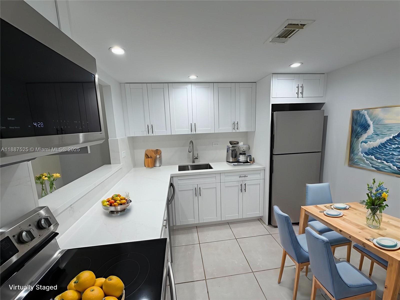 8101 Southwest 72nd Avenue, Unit 219W Miami, FL 33143 - Photo 15 of 30 a kitchen with a refrigerator a stove a microwave and a dining table