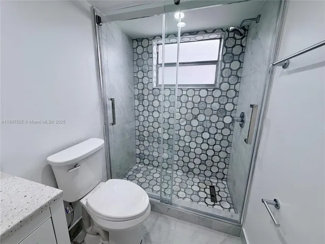 a bathroom with a toilet and a shower