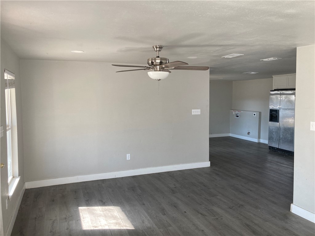600 West St Marys Street Mathis, TX 78368 - Photo 3 of 11 an empty room with wooden floor and windows