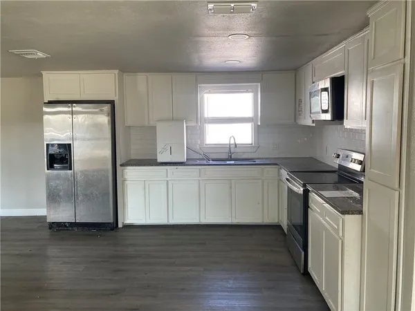 a kitchen with stainless steel appliances granite countertop a sink and a refrigerator