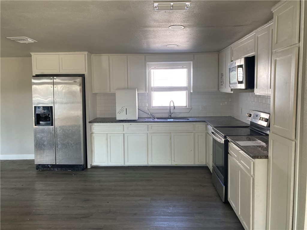 600 West St Marys Street Mathis, TX 78368 - Photo 4 of 11 a kitchen with stainless steel appliances granite countertop a sink and a refrigerator
