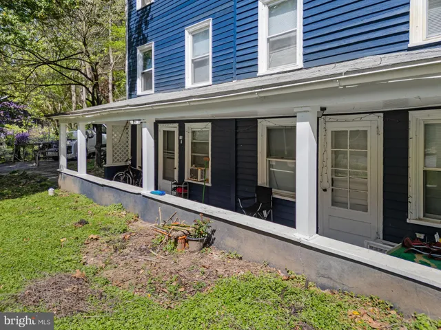 front view of a house with a large window and potted plants