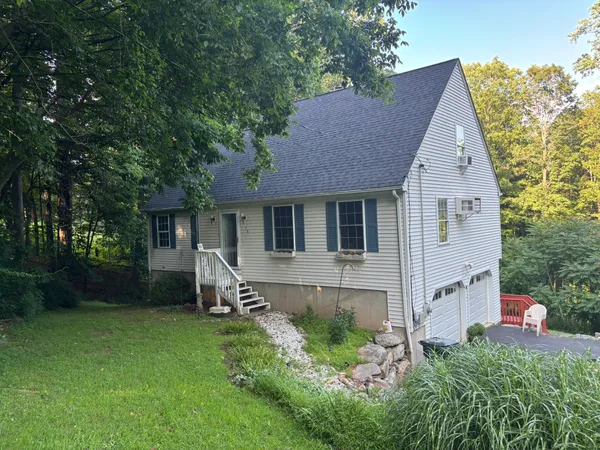 a view of a house with a yard and sitting area
