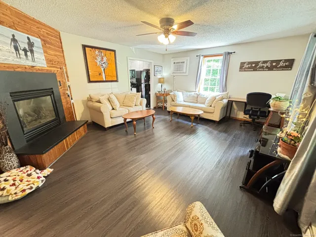 a living room with furniture floor to ceiling window and a flat screen tv