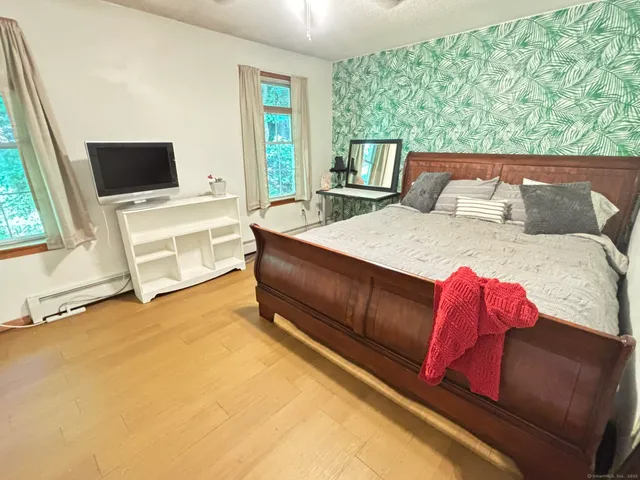 a living room with a bed furniture and next to a window