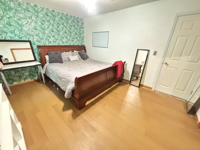 a bedroom with a bed and wooden floor
