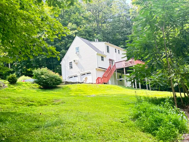a front view of a house with a yard and trees