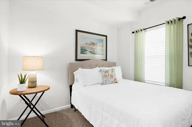 a bedroom with a bed and a lamp on dresser