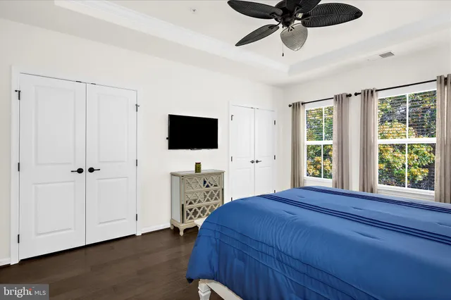 a bedroom with a bed and a flat tv screen on the dresser