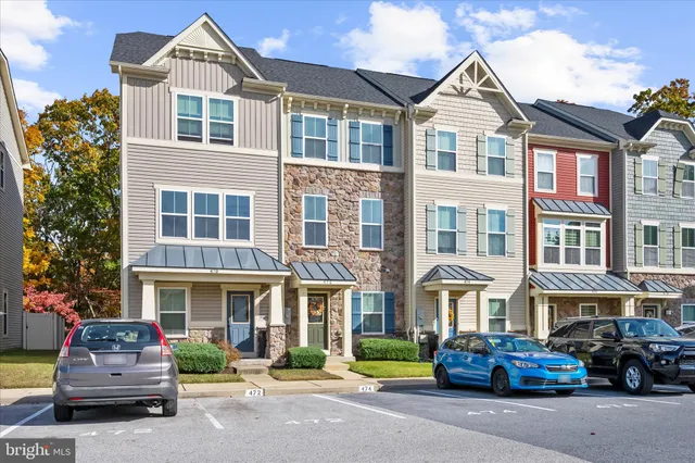 a front view of a building with cars parked