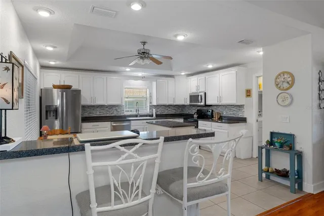 a kitchen with granite countertop white cabinets white stainless steel appliances with a sink and dishwasher