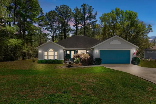 a front view of a house with yard and green space