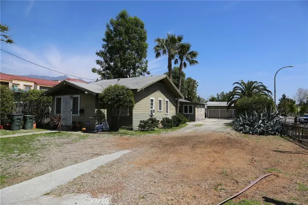 a front view of a house with a yard and potted plants