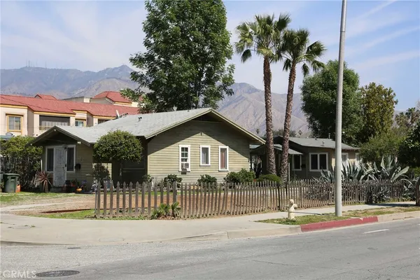 a front view of a house with a garden and plants
