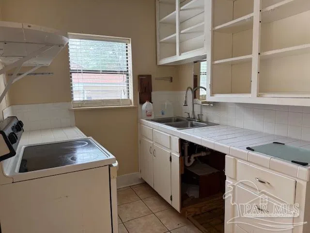 a kitchen that has a sink and a stove in it