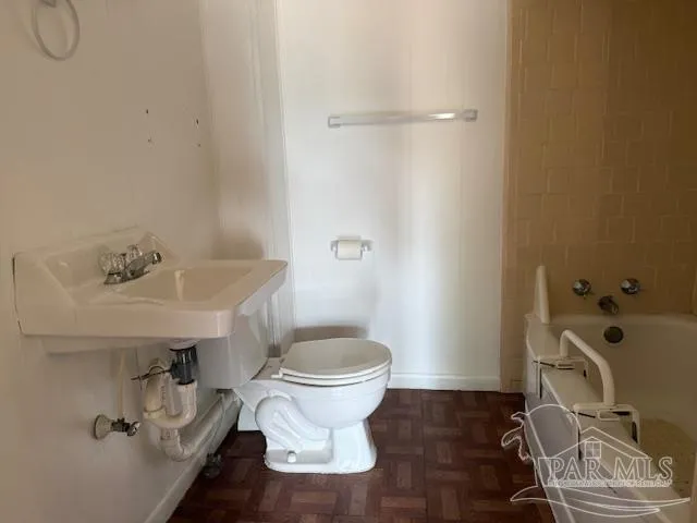 a bathroom with a sink toilet and a mirror