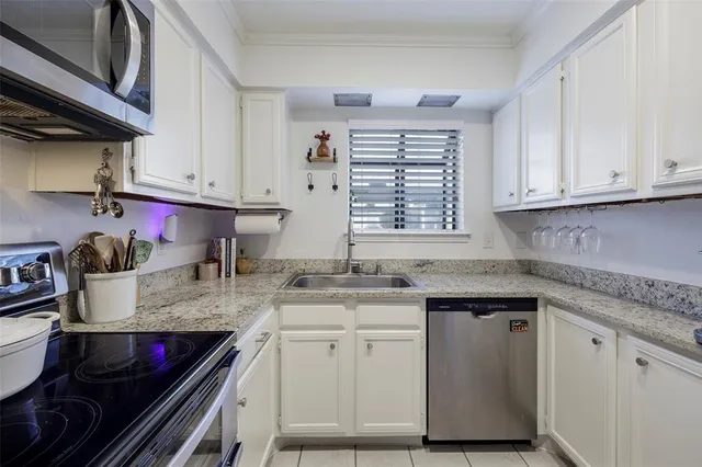 a kitchen with granite countertop a stove sink and cabinets