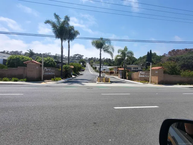 a view of a street with palm trees