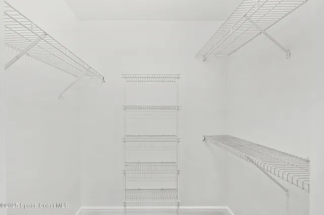 a view of a hallway with a chandelier fan