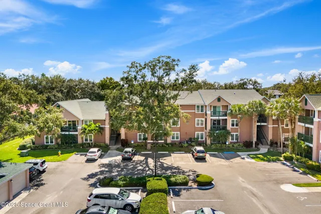 an aerial view of a city with lots of residential buildings ocean and mountain view in back