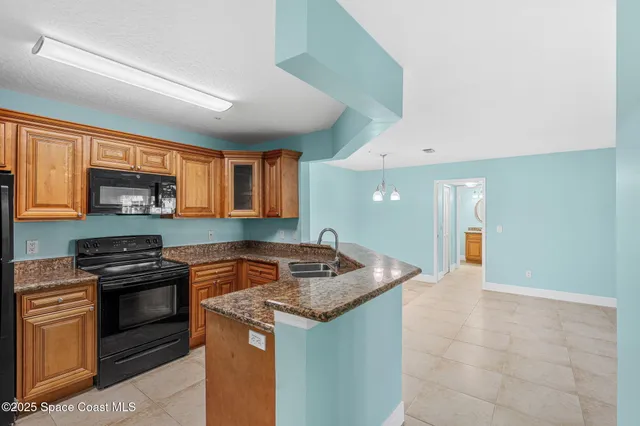 a kitchen with granite countertop a sink and a stove