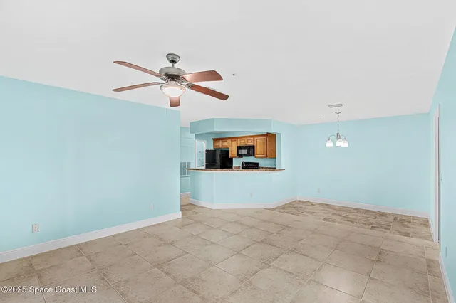 a view of a room with a ceiling fan and window