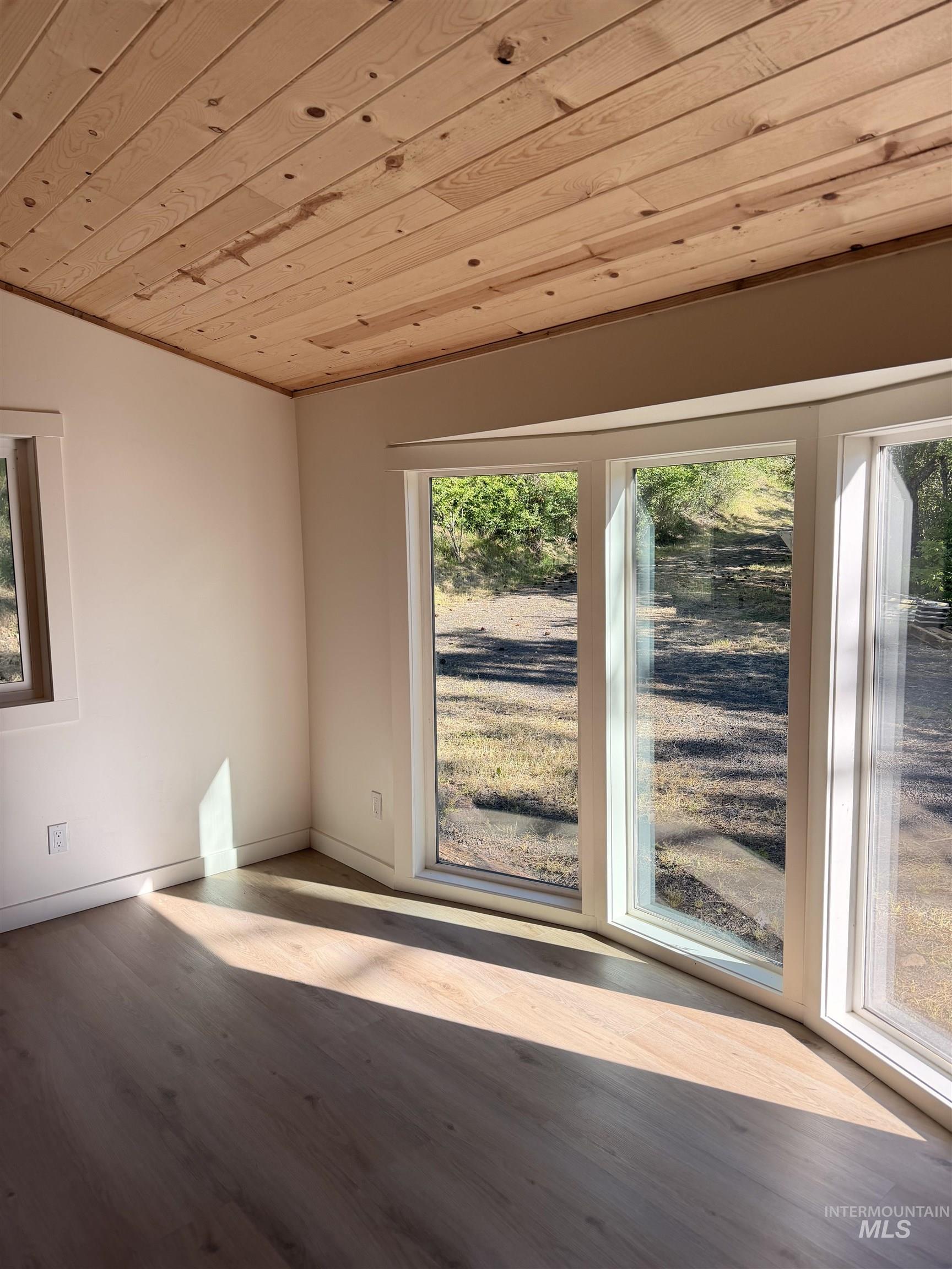 151 View Road Kamiah, ID 83536 - Photo 17 of 49 Room featuring wood-finish plank flooring, a wood-panel ceiling, and white painted walls