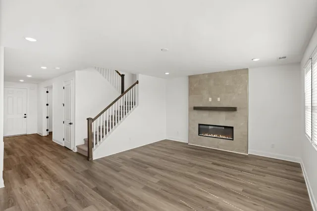 a view of empty room with wooden floor and fireplace