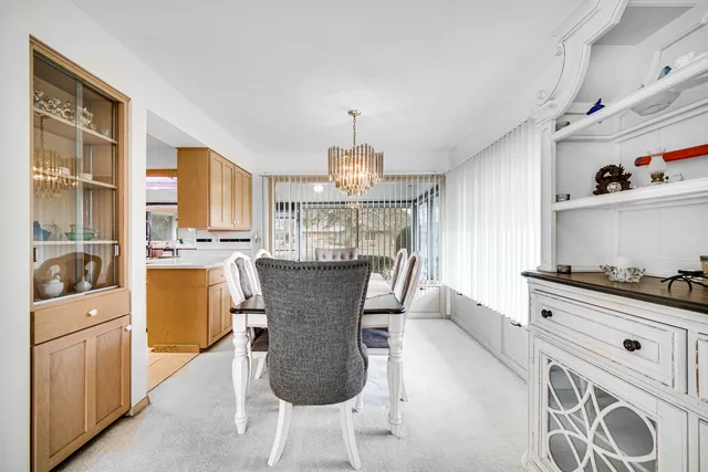 a view of a dining room with furniture a chandelier and wooden floor