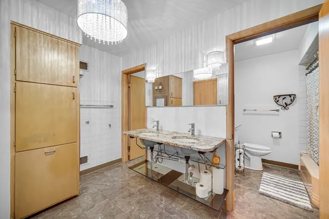 a bathroom with a sink a toilet and shower