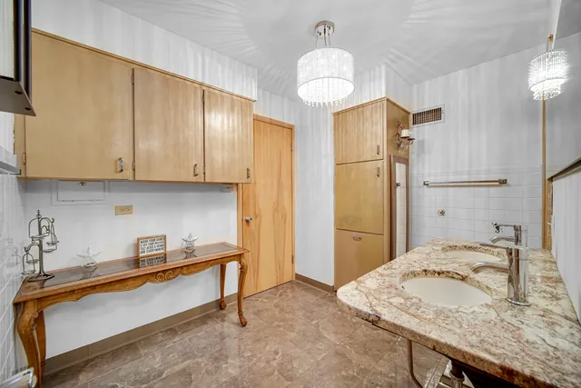 a kitchen with kitchen island granite countertop a sink cabinets and refrigerator