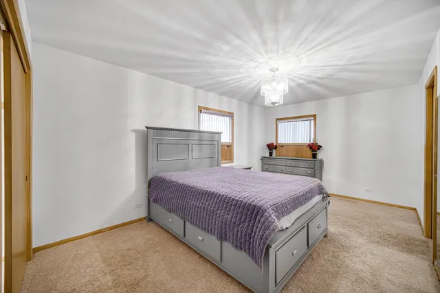 a bedroom with a large bed and a chandelier