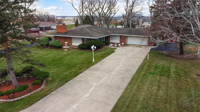 a front view of a house with yard and green space