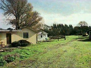 a view of backyard of house with green space