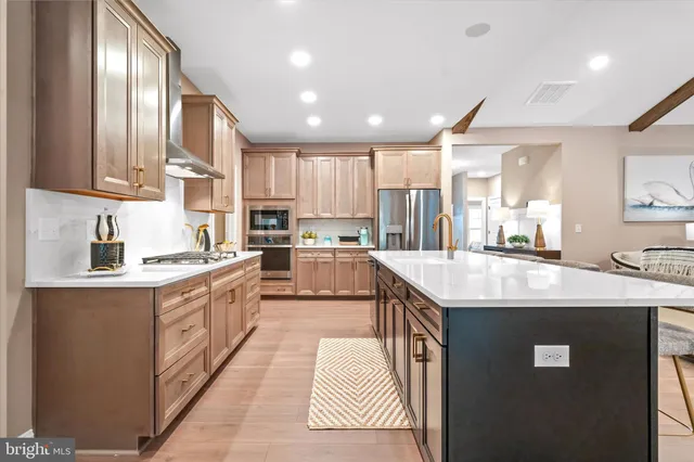 a kitchen with stainless steel appliances granite countertop a sink a stove and a refrigerator