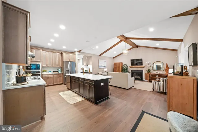 a large living room with stainless steel appliances kitchen island granite countertop a large counter top stainless steel appliances and cabinets