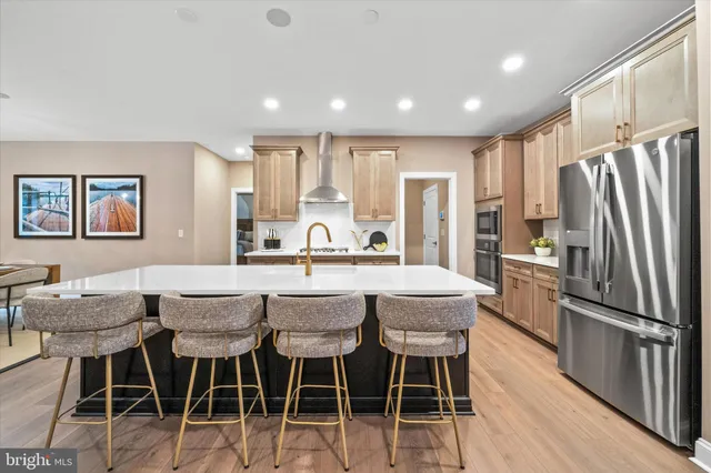 a kitchen with stainless steel appliances a dining table chairs and wooden floor