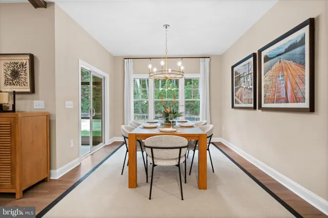 a dining room with furniture a chandelier and wooden floor