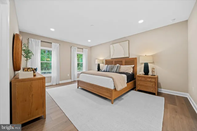 a bedroom with a bed and large windows