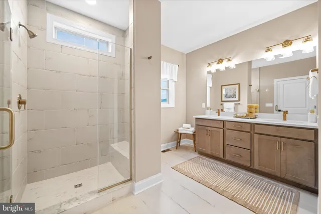 a bathroom with a double vanity sink a toilet and shower