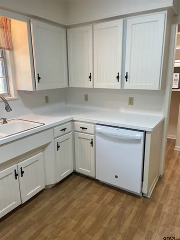 a kitchen with white cabinets white stainless steel appliances and sink