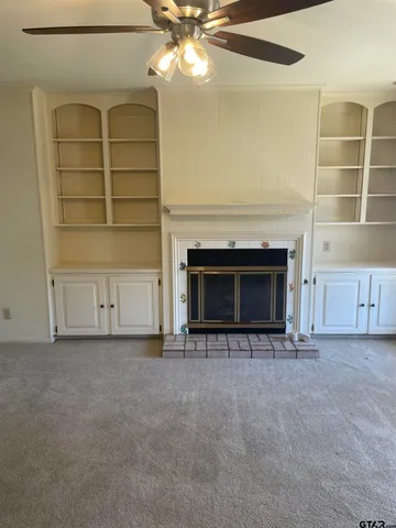 an empty room with a fireplace and cabinet