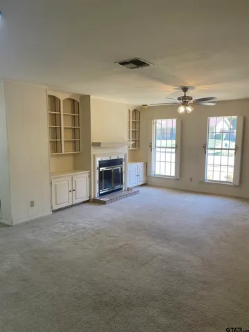 an empty room with fireplace and windows