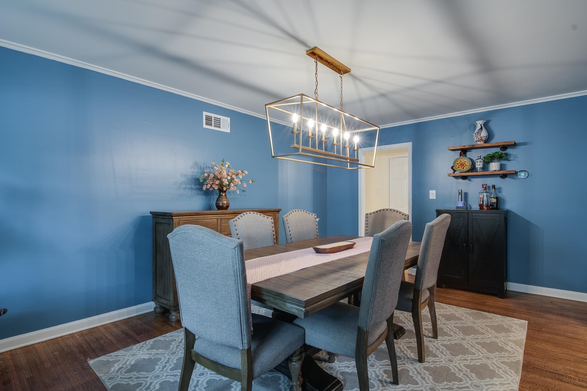 4898 Dee Road Memphis, TN 38117 - Photo 22 of 40 a dining room with furniture a chandelier and wooden floor