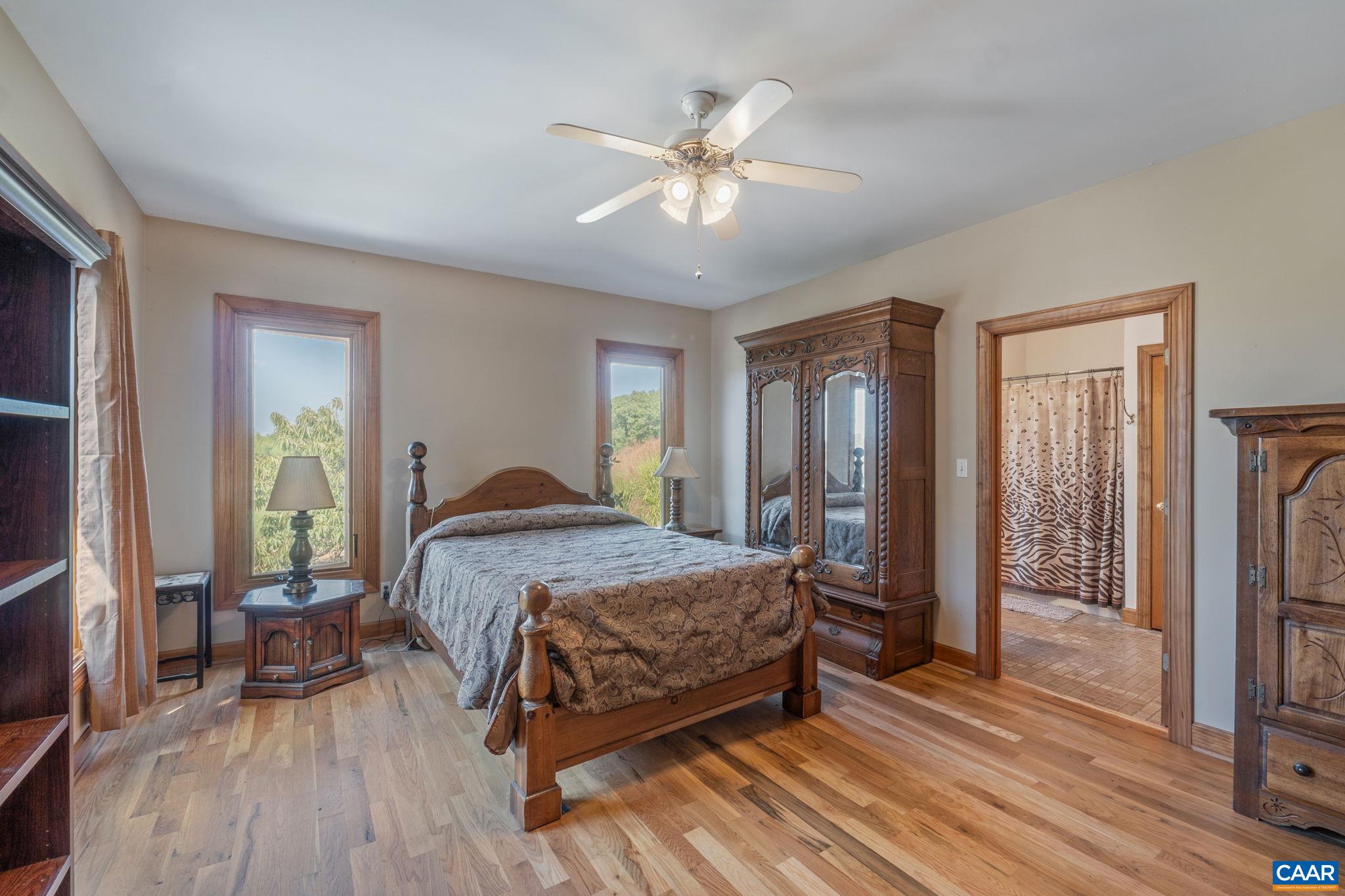 3535 Venable Road Kents Store, VA 23084 - Photo 20 of 75 a spacious bedroom with a bed and a chandelier