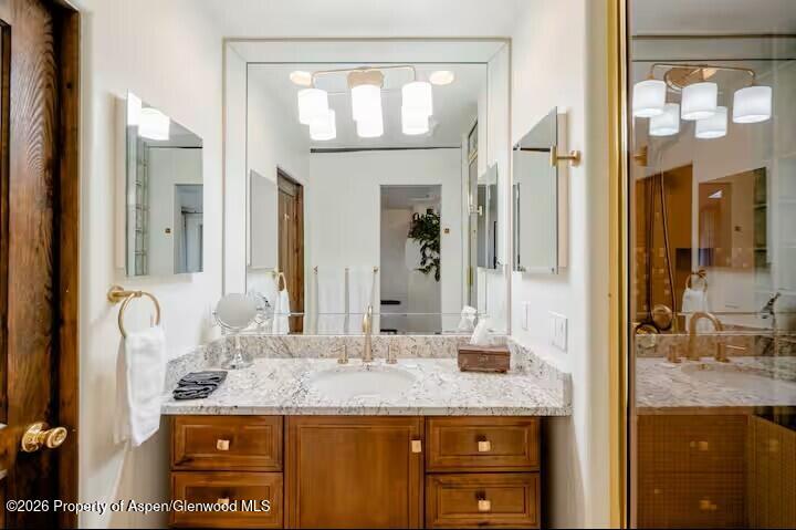 107 Aspen Mountain Road, Unit 9 Aspen, CO 81611 - Photo 11 of 19 a bathroom with a granite countertop sink and a mirror