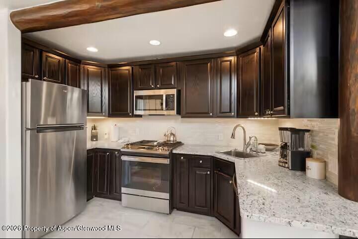 107 Aspen Mountain Road, Unit 9 Aspen, CO 81611 - Photo 3 of 19 a kitchen with stainless steel appliances granite countertop a sink stove and refrigerator