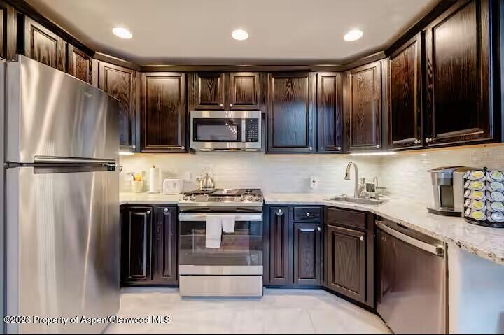 107 Aspen Mountain Road, Unit 9 Aspen, CO 81611 - Photo 4 of 19 a kitchen with stainless steel appliances granite countertop a refrigerator a stove a sink and a microwave