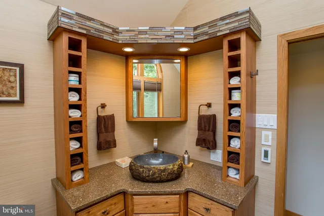 an aerial view of residential house with outdoor space and trees all around