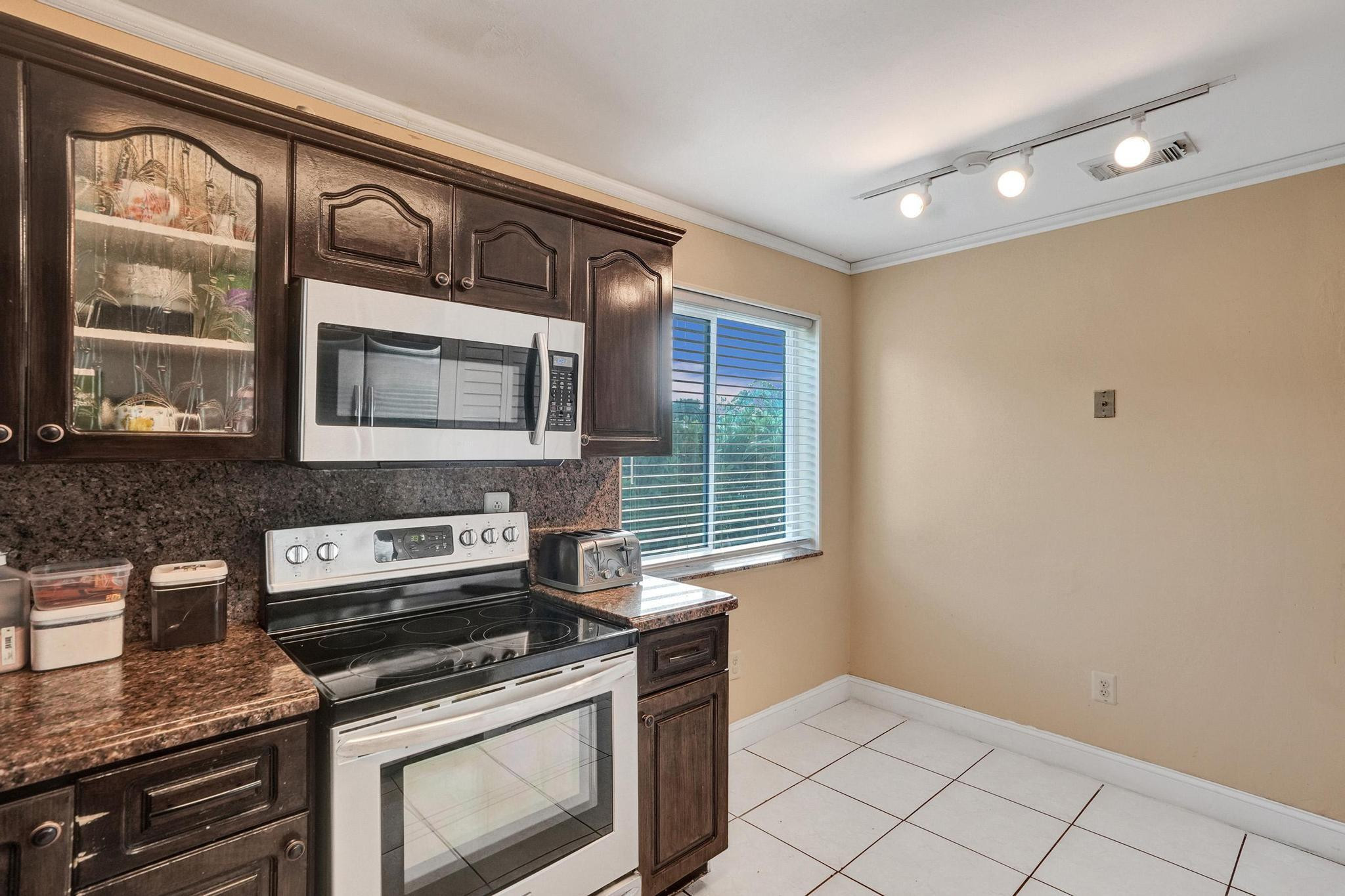 26205 Southwest 133rd Court Homestead, FL 33032 - Photo 22 of 45 a kitchen with stainless steel appliances granite countertop a stove and a microwave